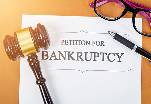 Petition for Bankruptcy document with a gavel, pen, and glasses.