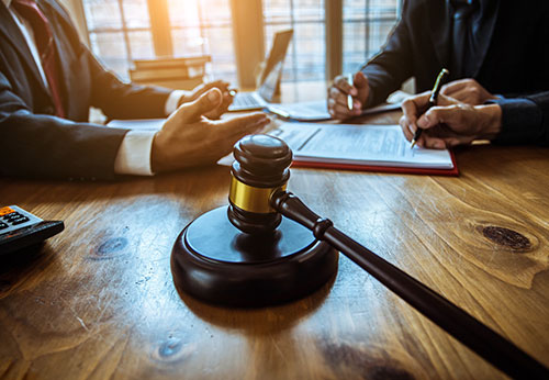 Close-up of a judge’s gavel on a desk during a legal consultation.
